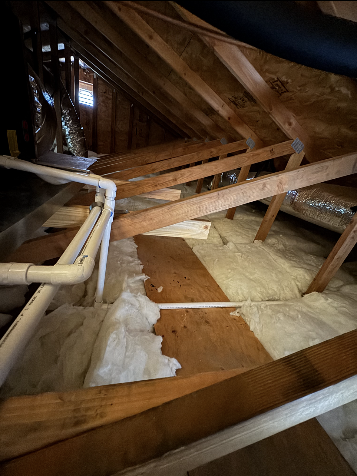 There is a lot of insulation in the attic of a house.