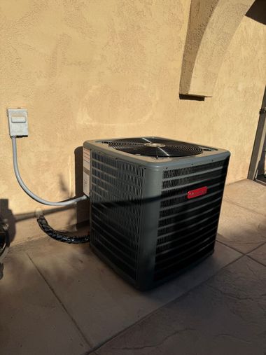An air conditioner is sitting on a tiled floor next to a wall.