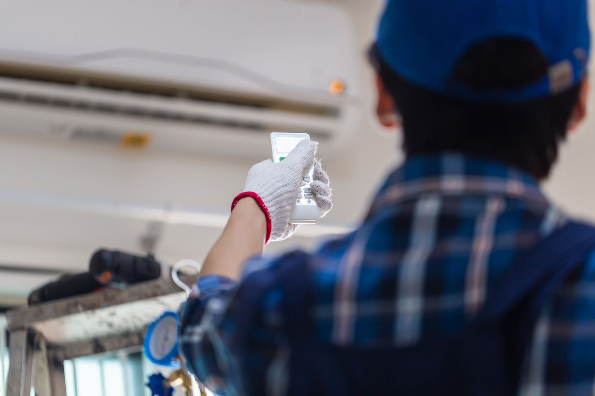 A man is working on an air conditioner in a room.