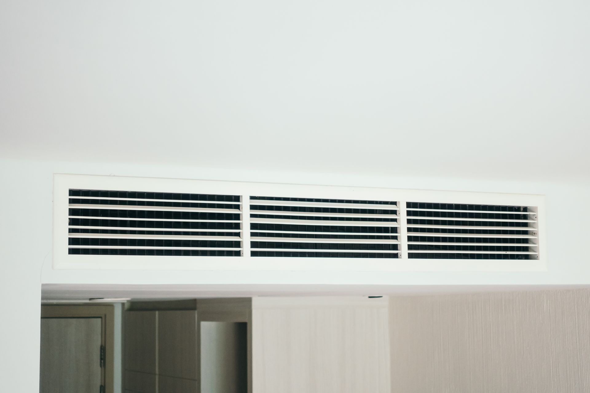 A close up of a ceiling air vent in a room.