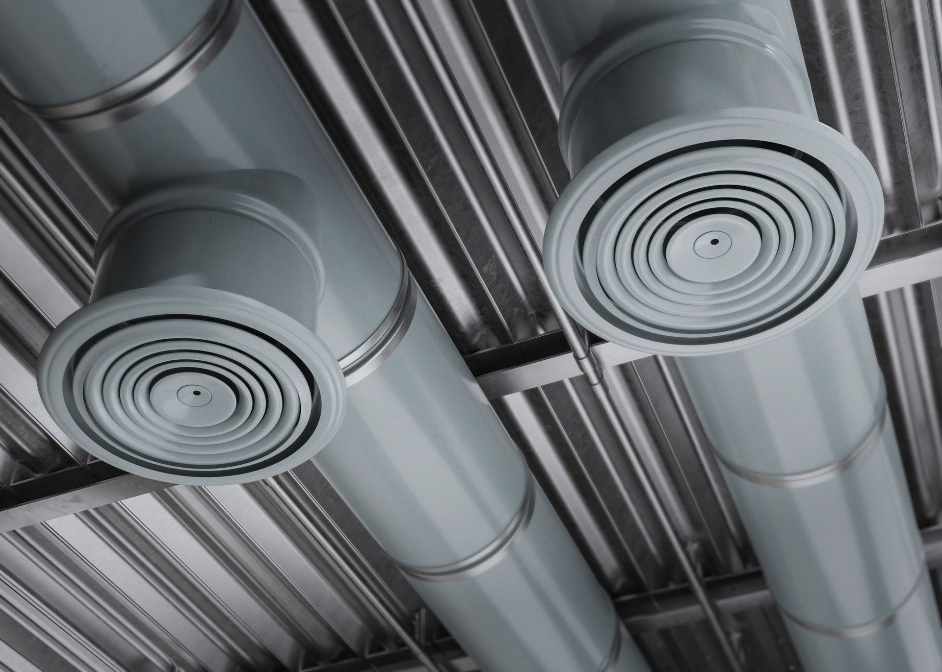 A bunch of ducts are hanging from the ceiling of a building.