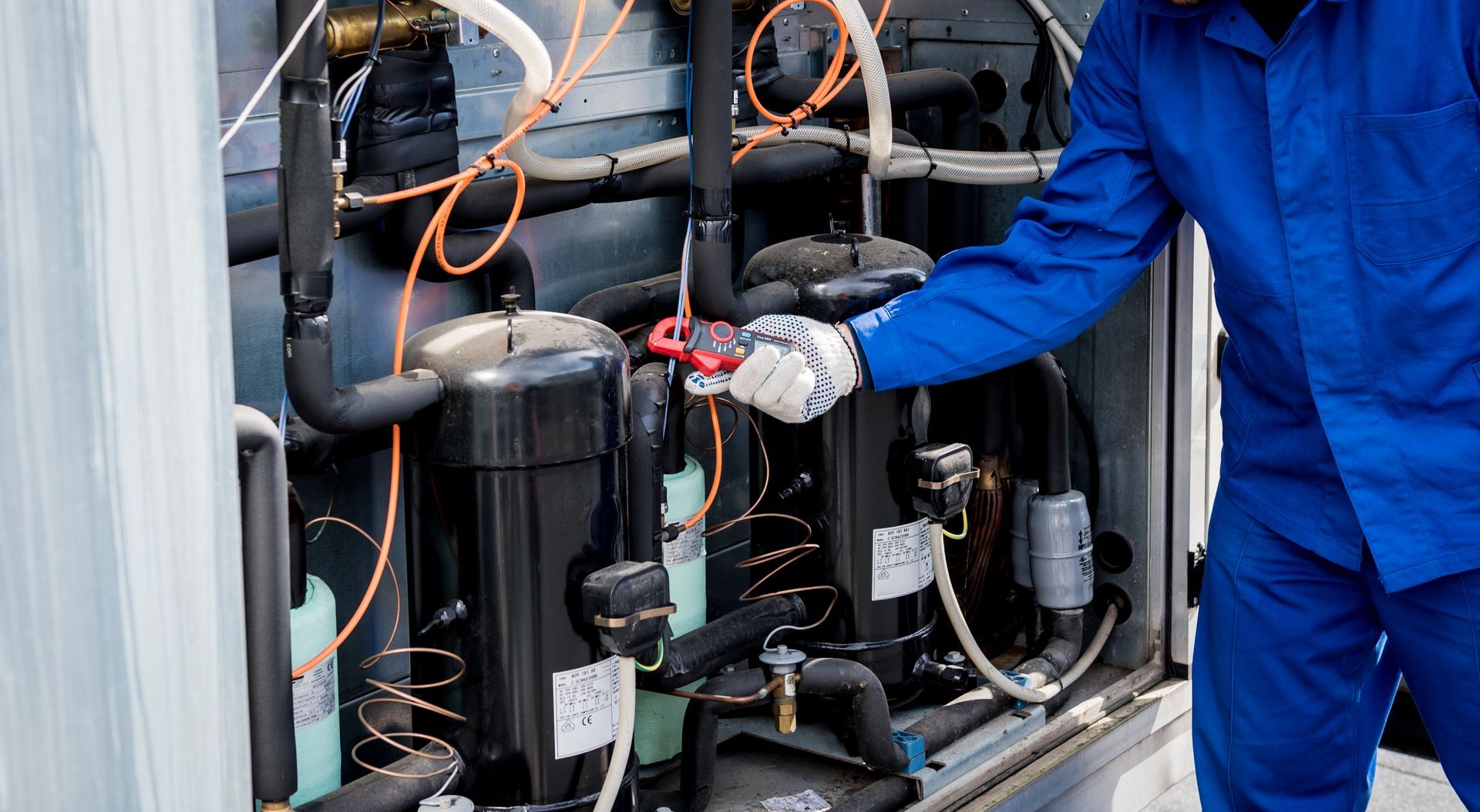 A man in a blue jacket is working on a machine.