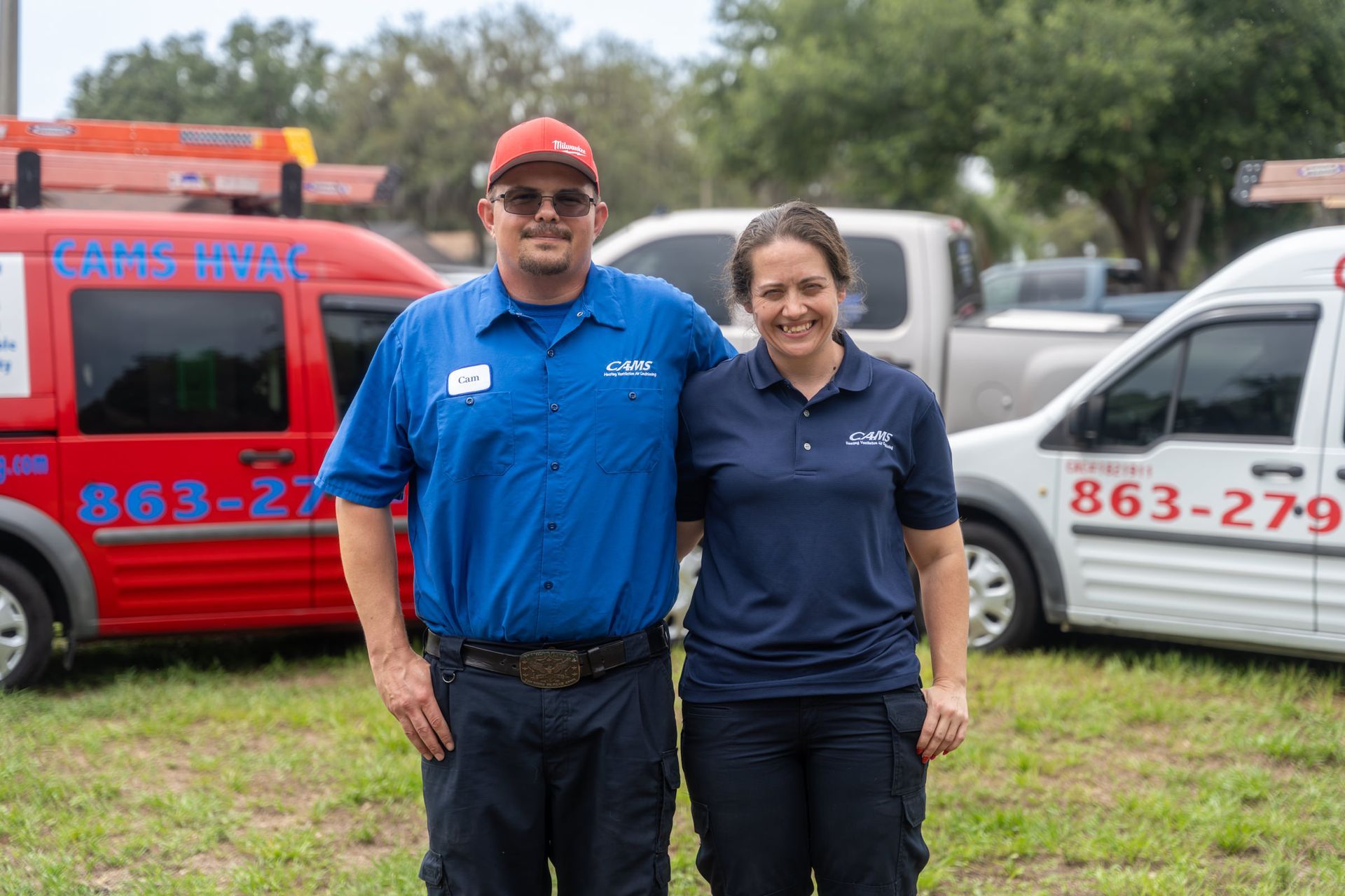 A man and a woman are posing for a picture in front of a van.