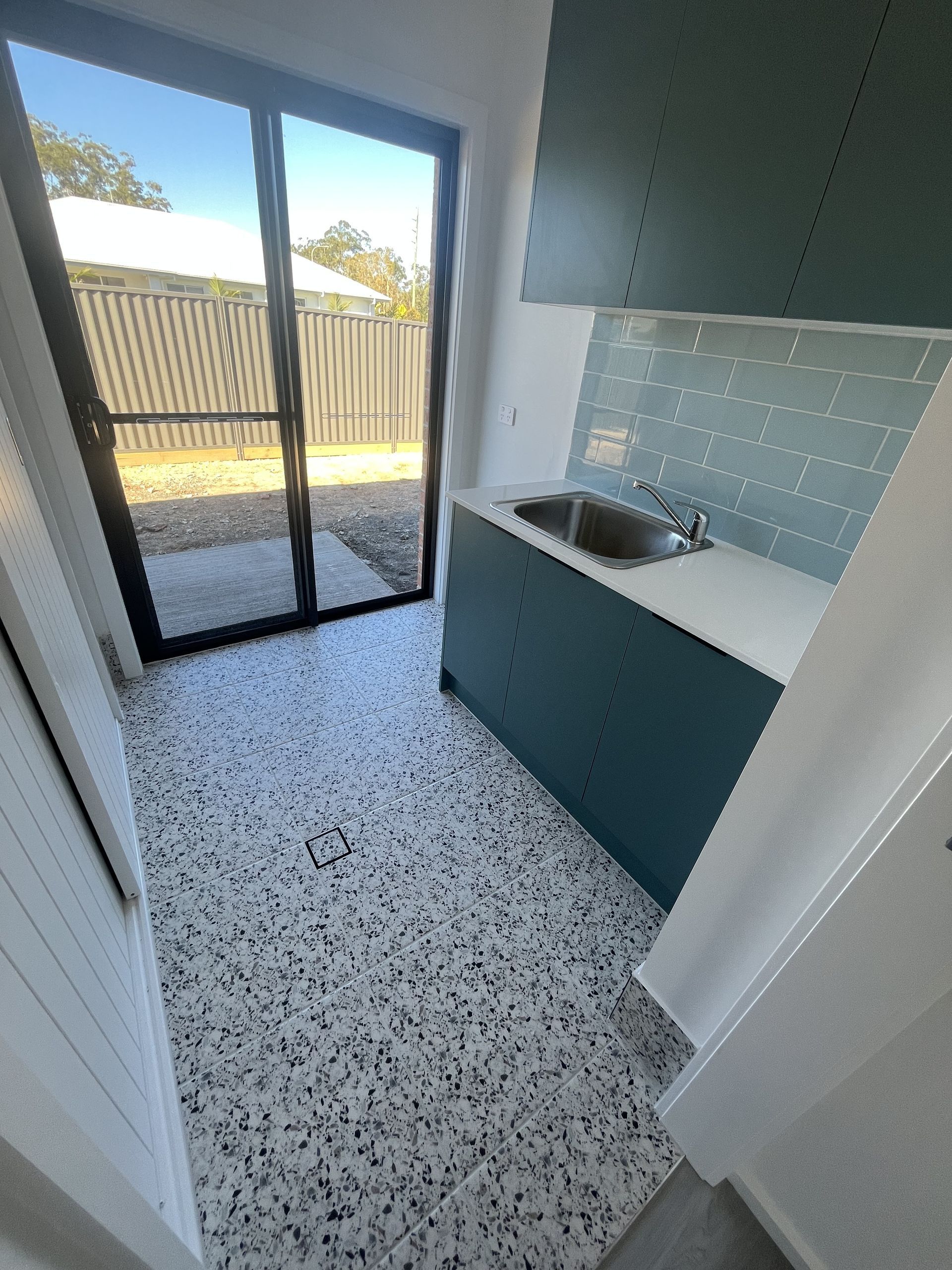 Laundry Room with Blue Cabinetry, Sink, Light Blue Tile Backsplash — Midcoast Wall & Floor Tiling in Woolgoolga, NSW