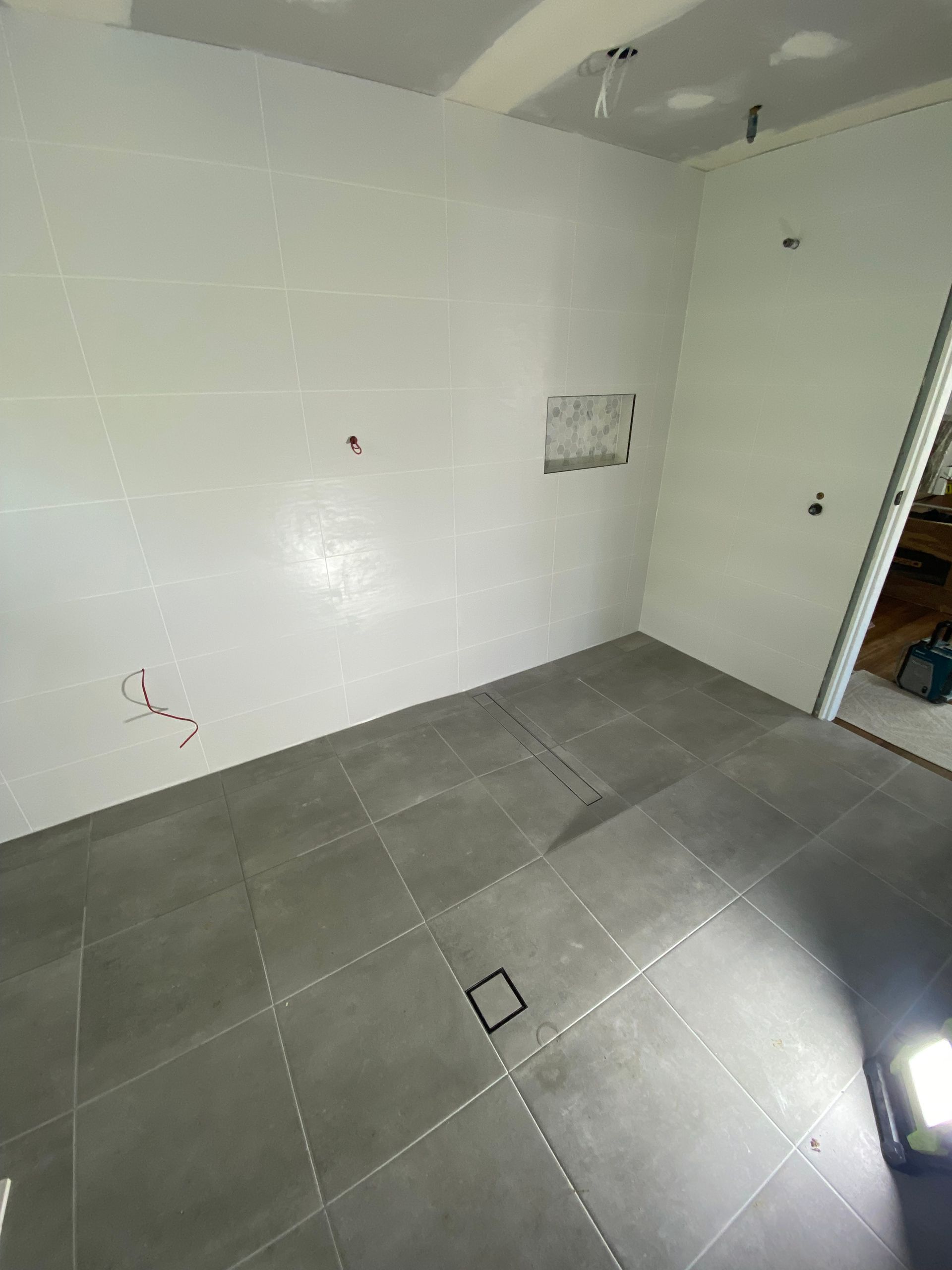 Gray-Tiled Room with White Walls. Open Doorway on Right — Midcoast Wall & Floor Tiling in Woolgoolga, NSW