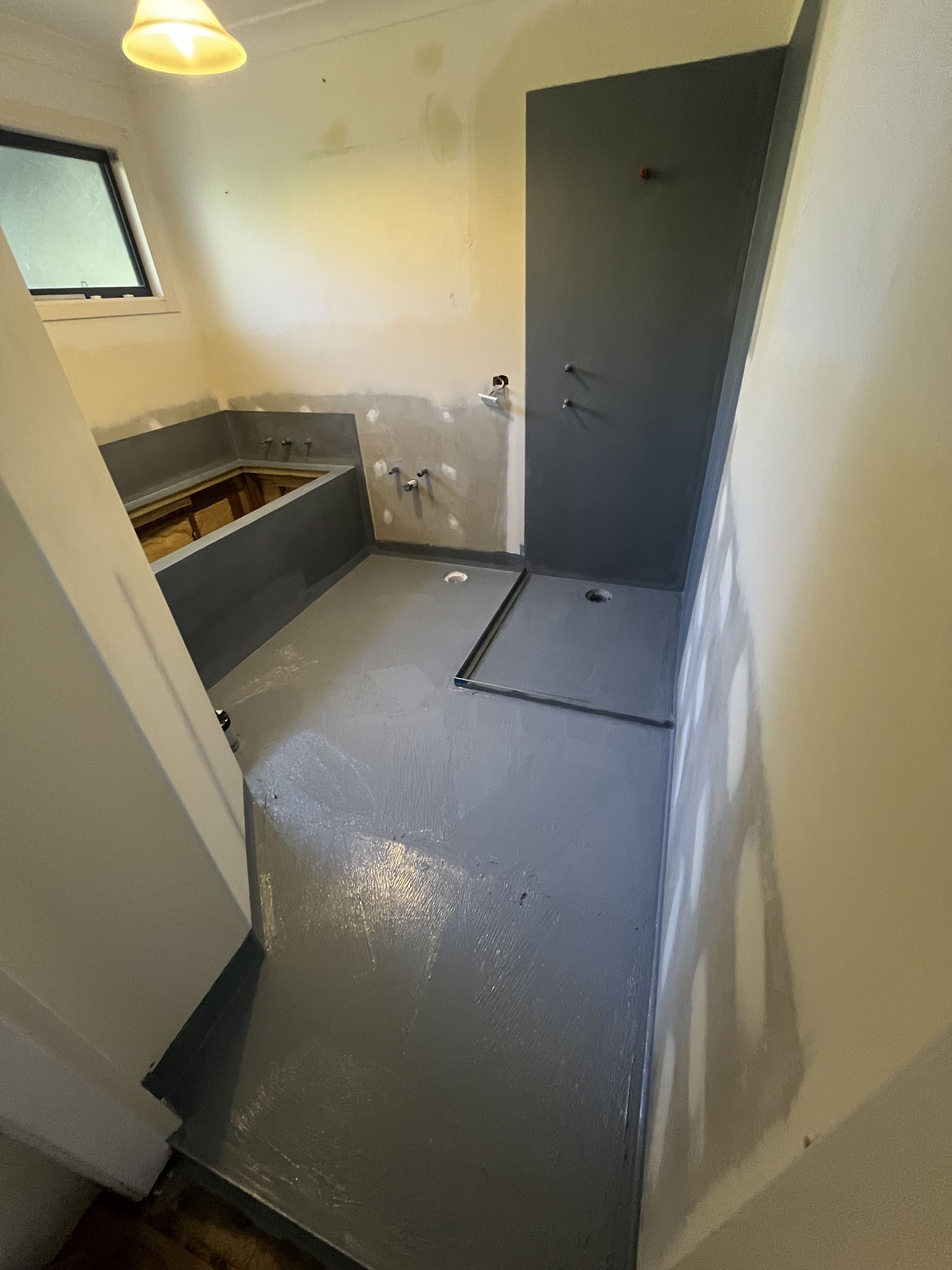 Bathroom with Beige Tiled Walls and Floor, a Window, and Recessed Shelving — Midcoast Wall & Floor Tiling in Woolgoolga, NSW