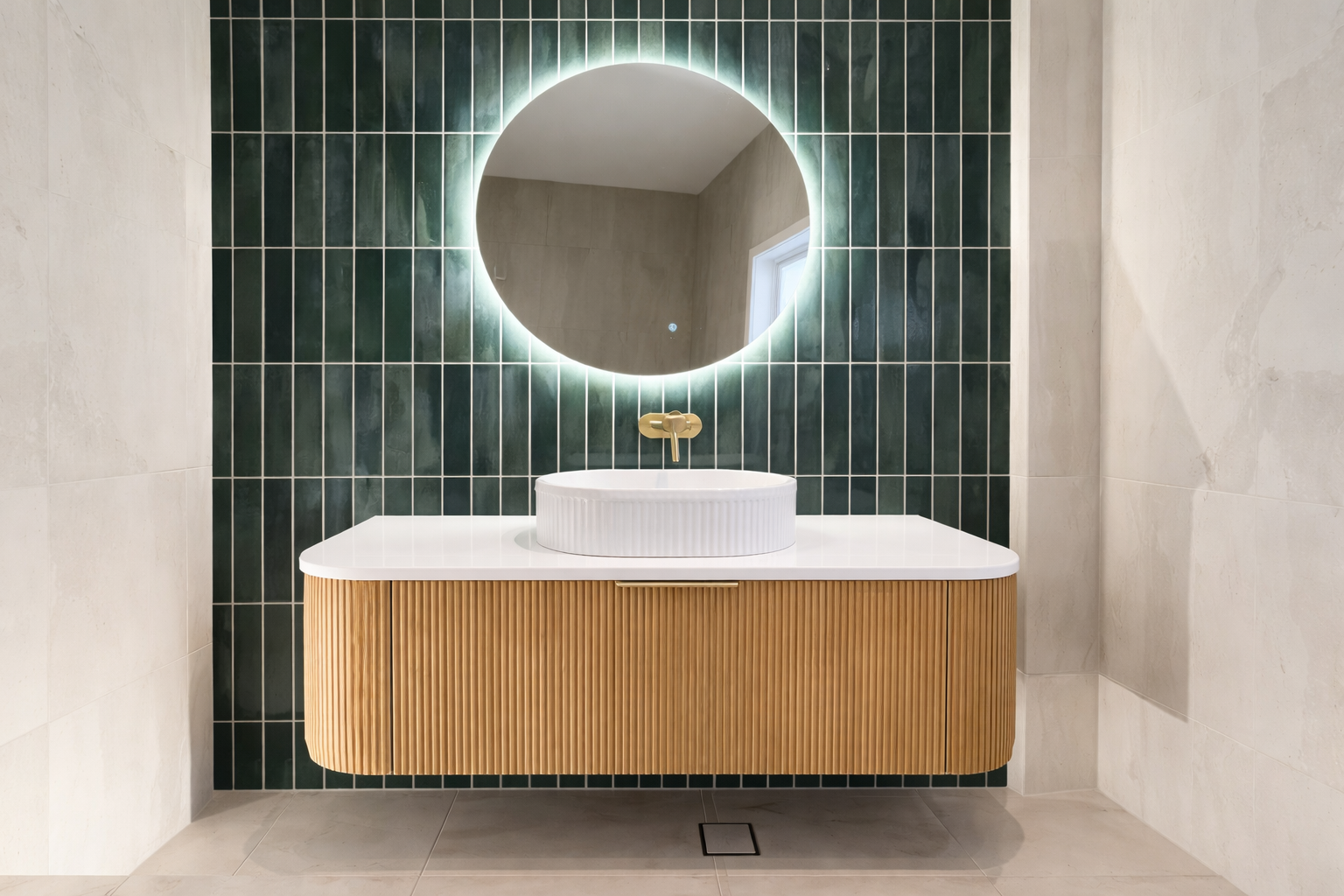 A white bathtub against tiled walls, with a yellow throw blanket and candle on a small wooden stool on patterned flooring.