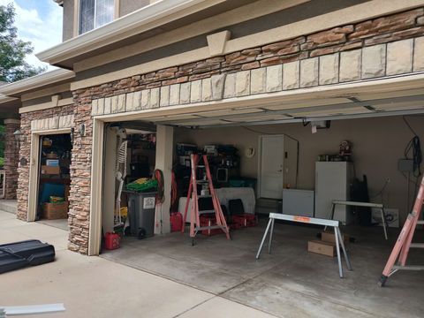 Open garage with ladders, tools, and workbench during home renovation