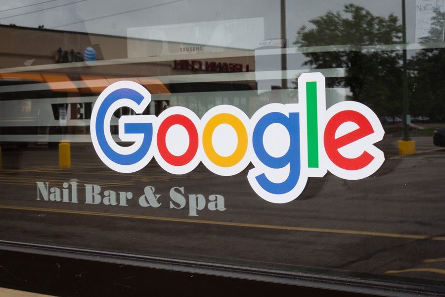 Google logo on a window of a nail salon, blue, red, yellow, and green colors. 