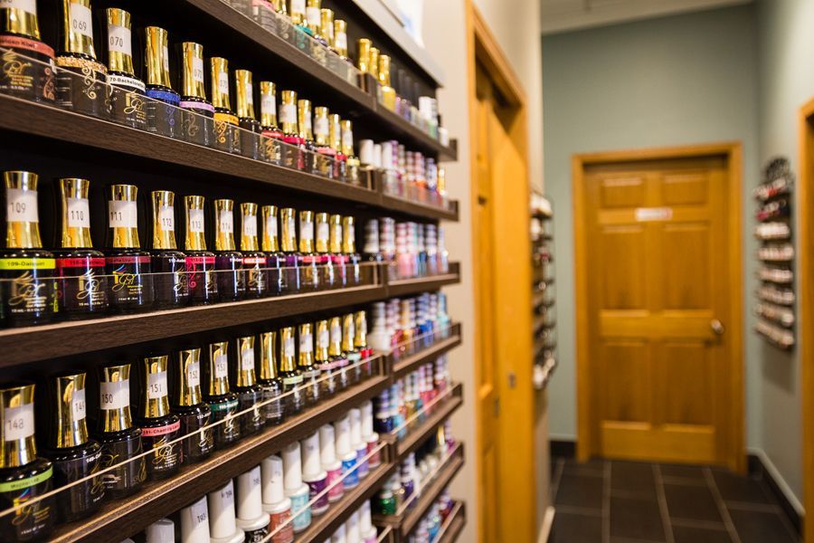 Shelves of colorful nail polish bottles in a nail salon.