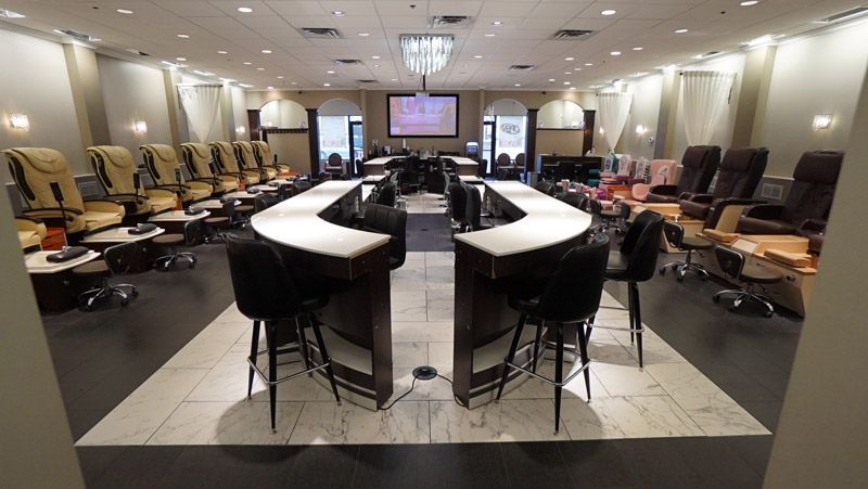 Interior of a nail salon with manicure stations and massage chairs.