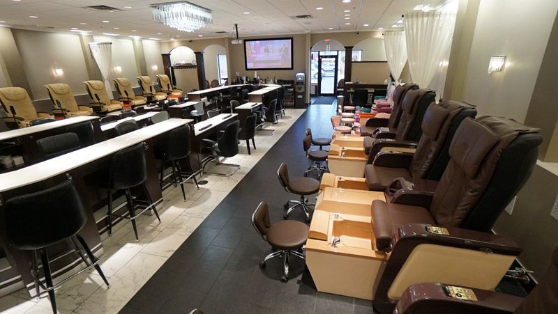 Nail salon interior with pedicure stations and manicure tables.