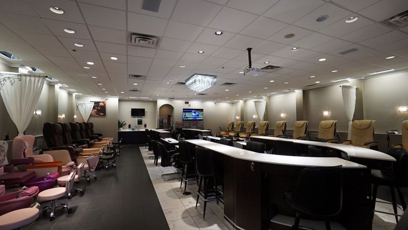 Interior of a nail salon with stations for manicures and pedicure chairs.