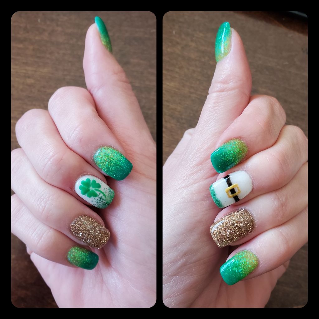 Two hands with St. Patrick's Day-themed nail art: shamrocks, gold glitter, and green ombre.