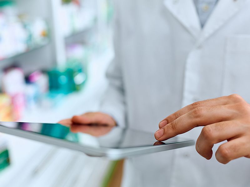 Un farmacista sta utilizzando un tablet in una farmacia.