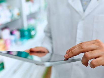Un farmacista sta utilizzando un tablet in una farmacia.