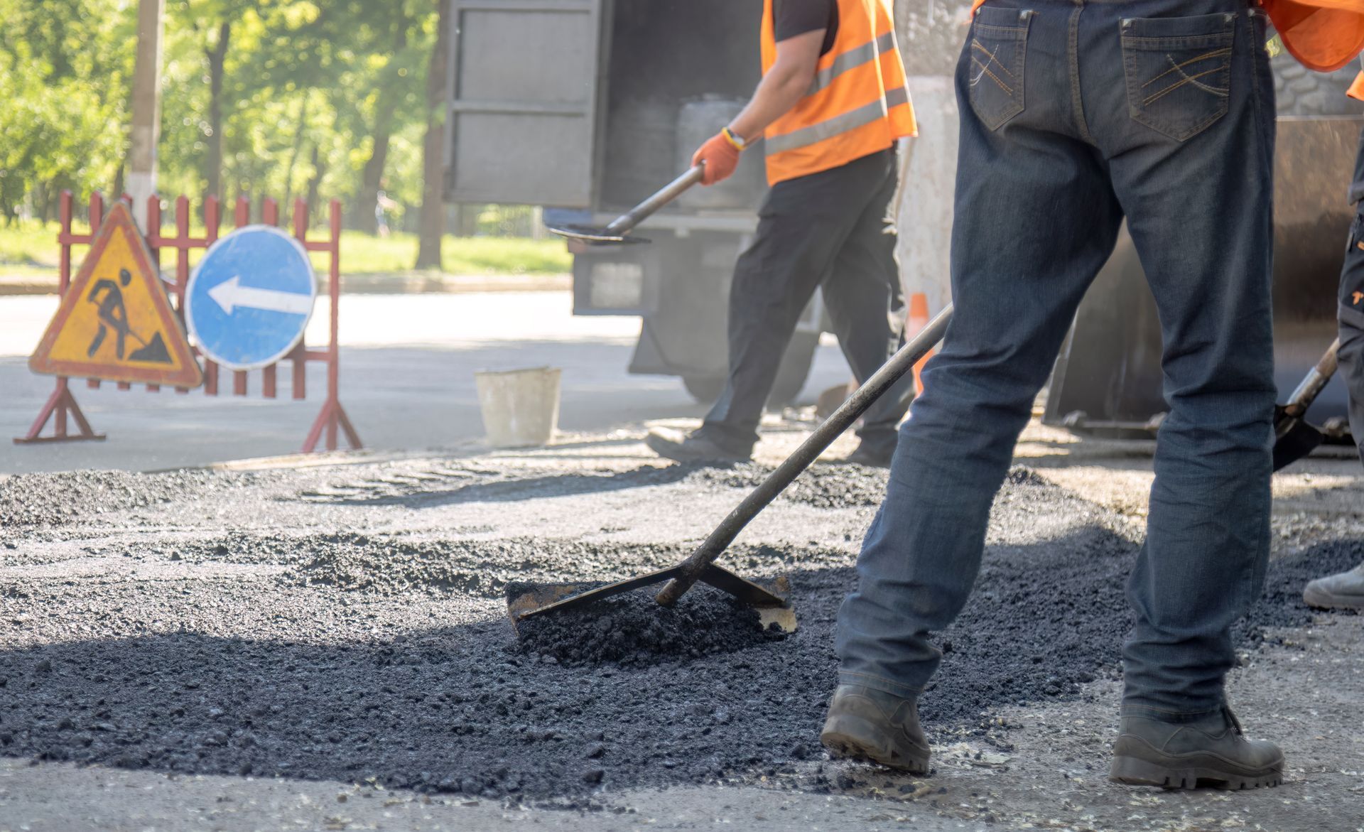 Commercial paving contractor crew installing fresh asphalt on roadway construction project.