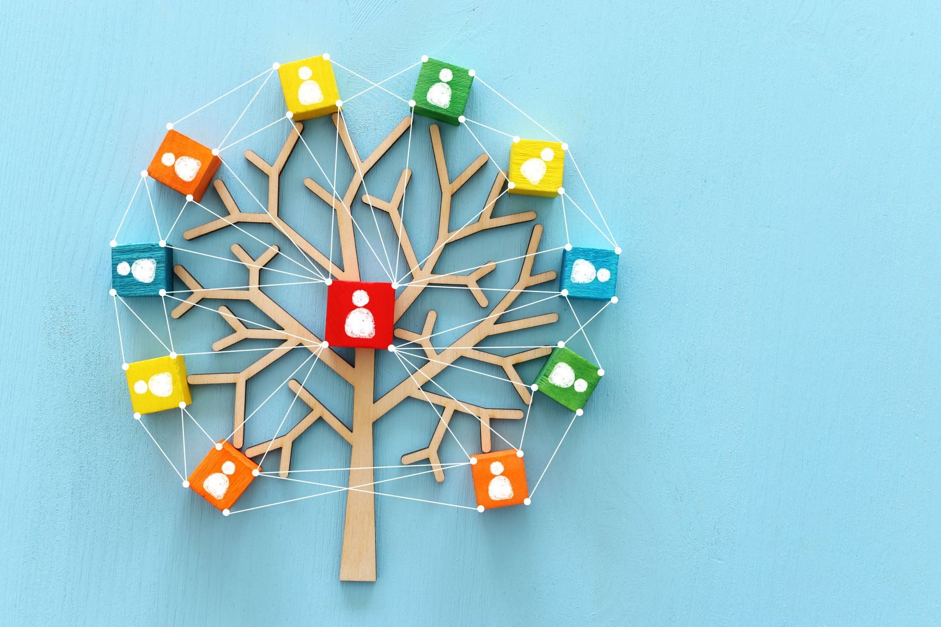 A tree made of wooden blocks with people 's faces on them on a blue background.