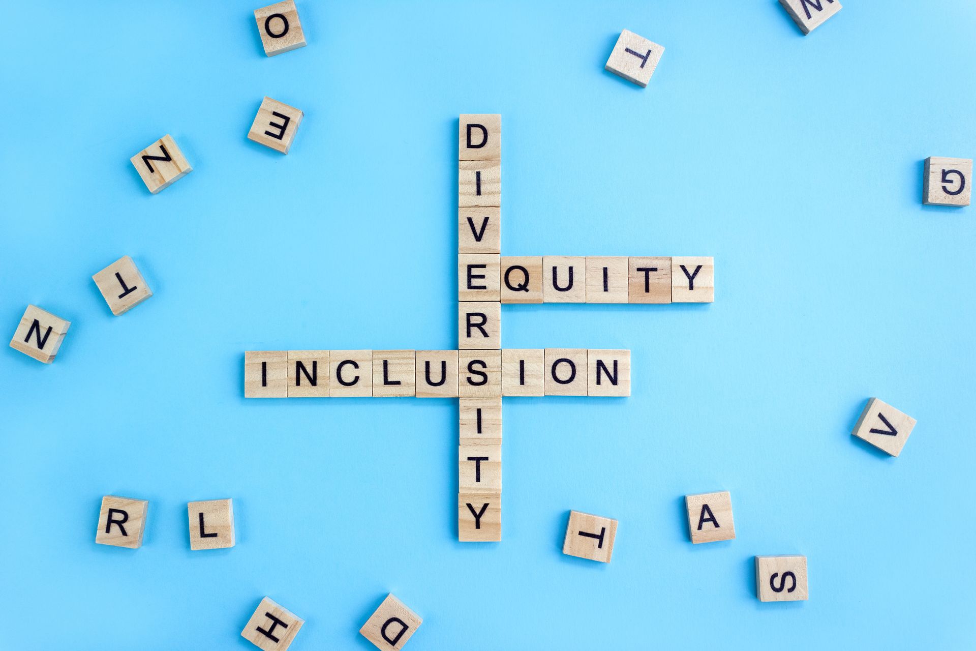 The word inclusion is written in scrabble blocks on a blue background.