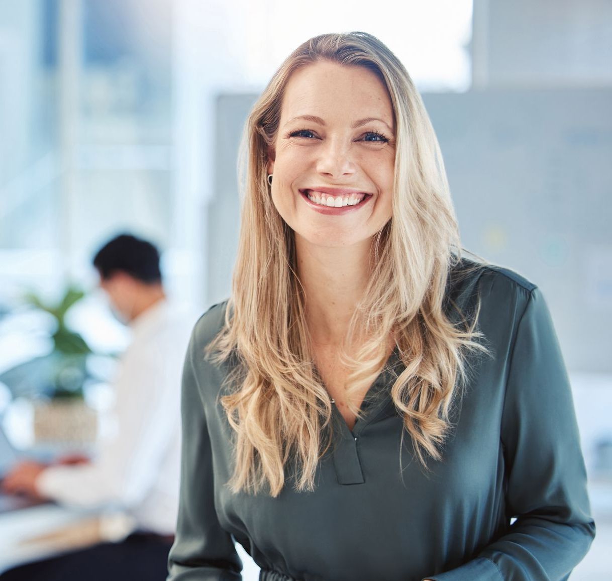 A woman in a green shirt is smiling for the camera