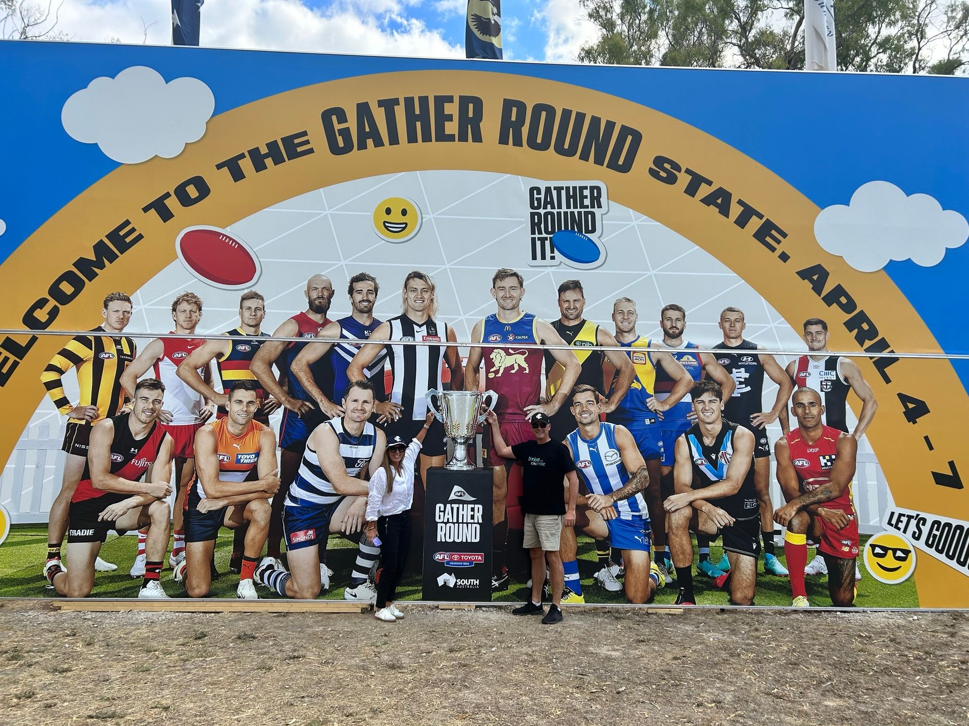 A group of men are posing for a picture in front of a sign that says 