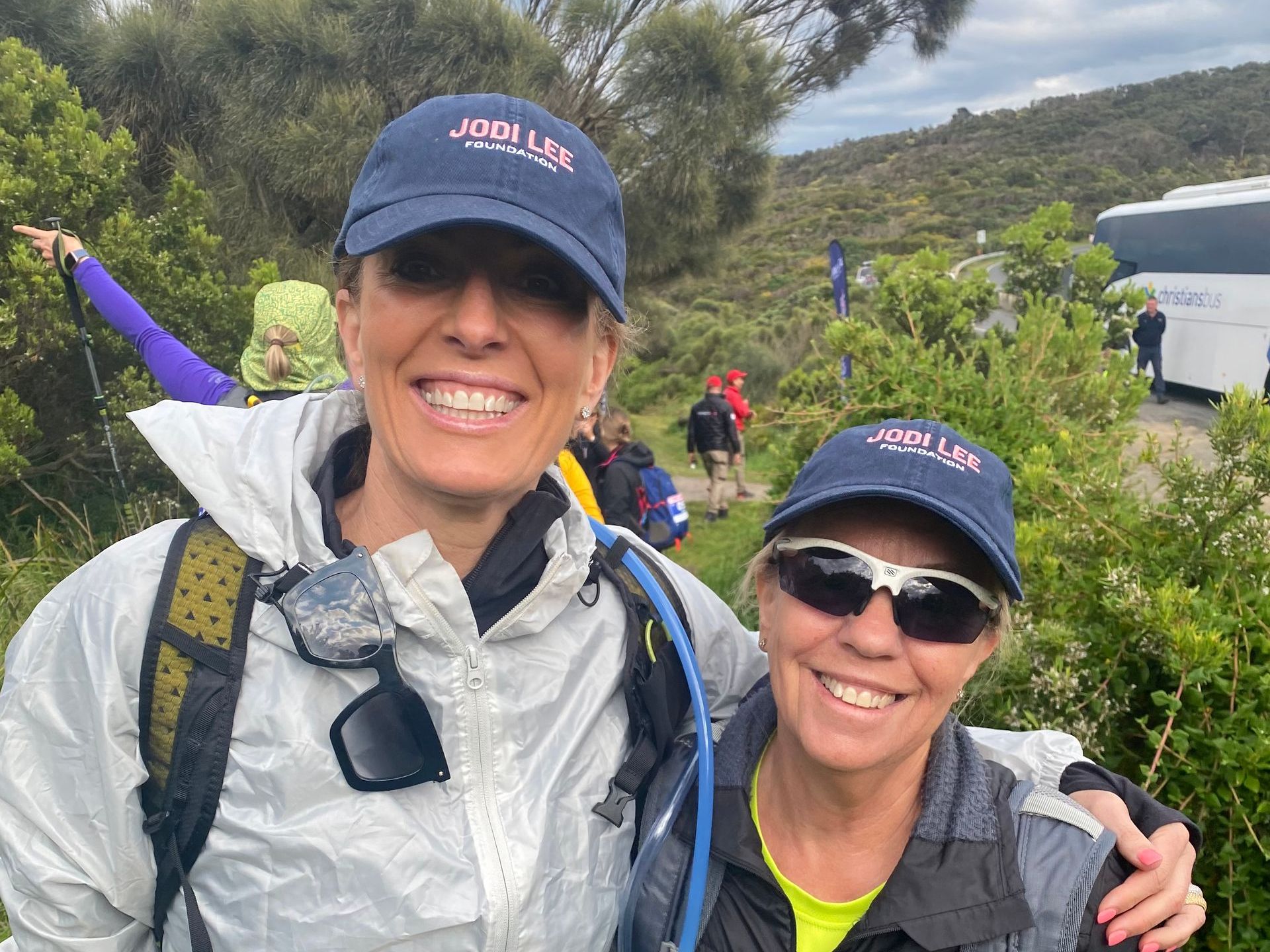 Two women wearing hats and sunglasses are posing for a picture.