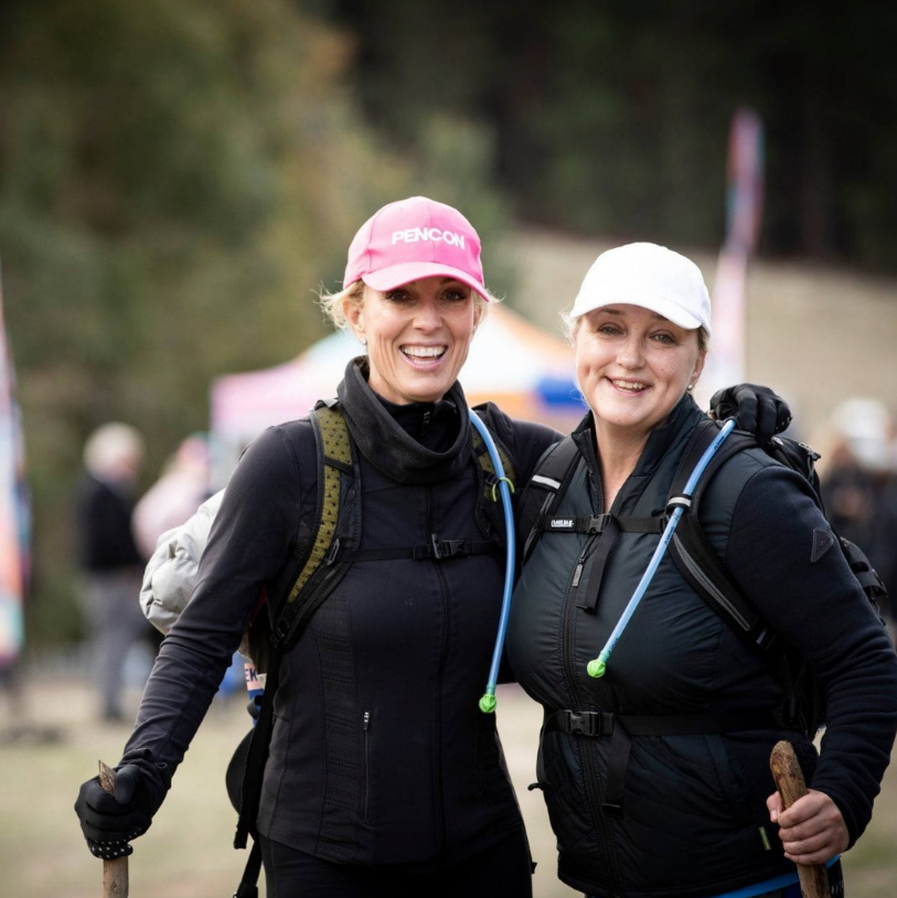 Two women are posing for a picture with one wearing a pink hat that says pennsylvania
