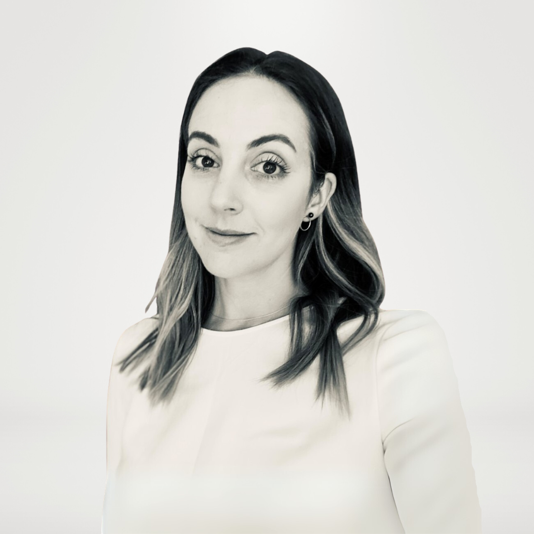 A woman in a white shirt is smiling in a black and white photo.