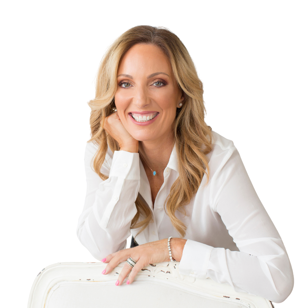 A woman in a white shirt is sitting in a white chair and smiling.