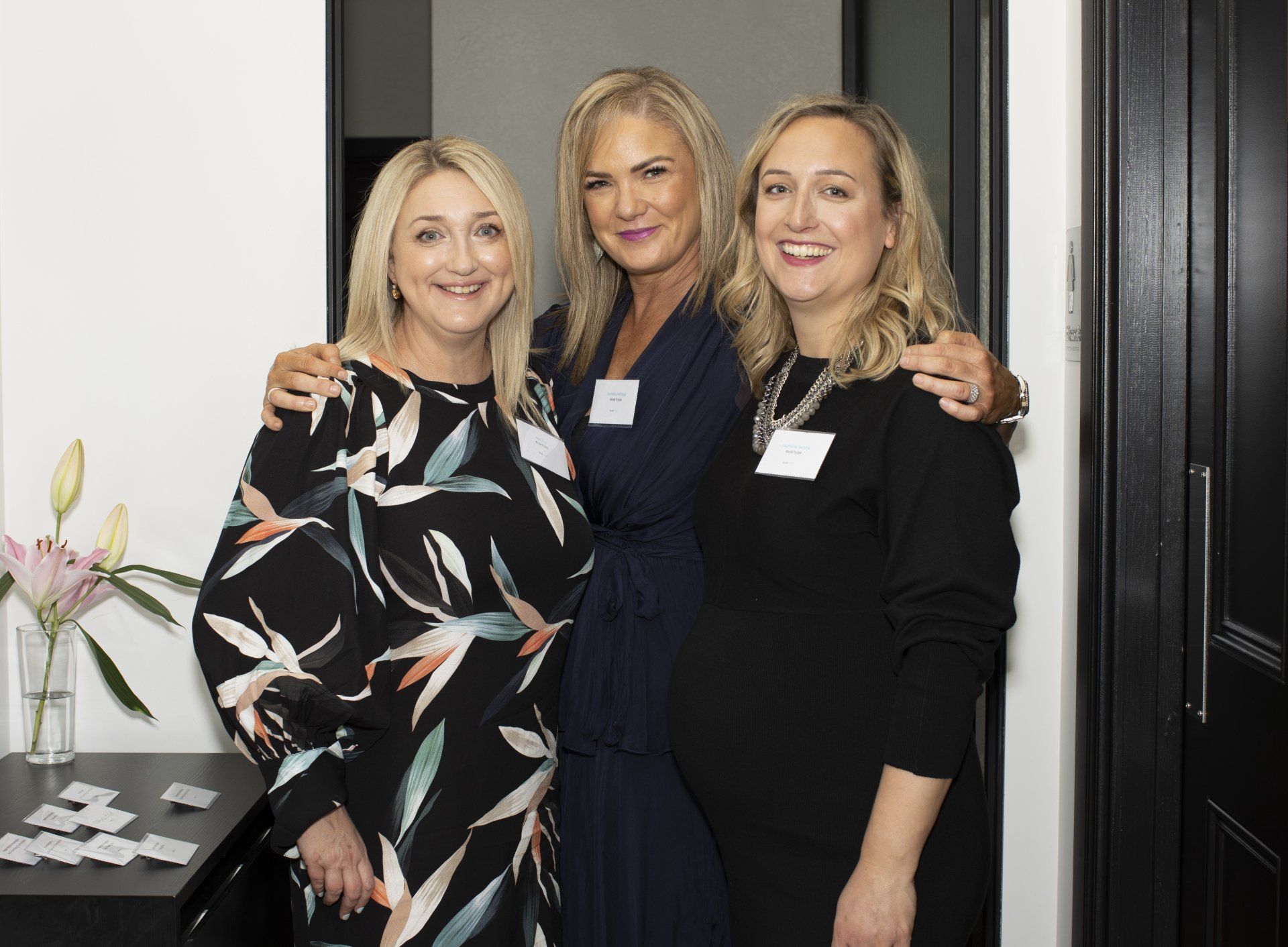 Three women are posing for a picture together in a room.