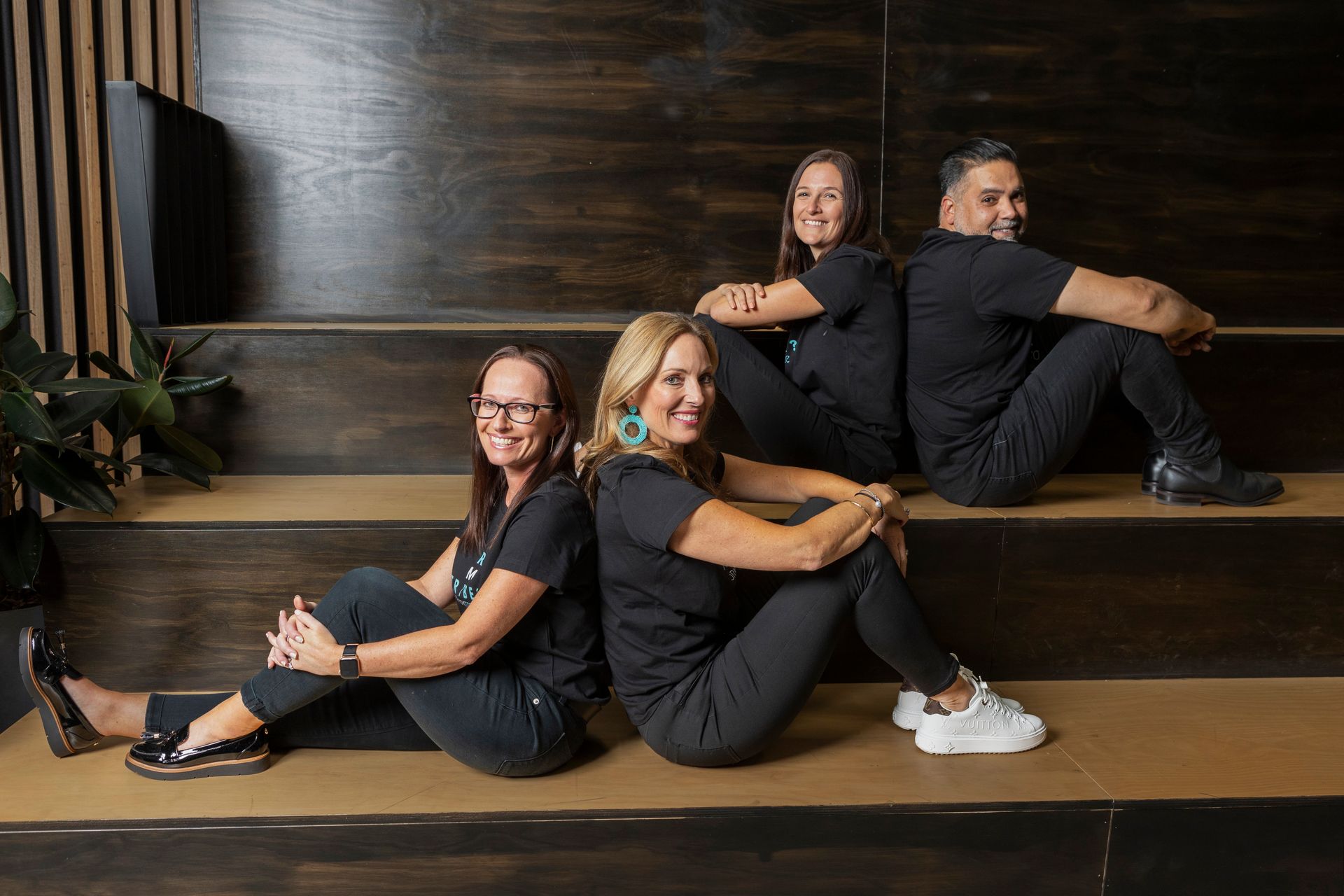 A group of people are posing for a picture while sitting on steps.