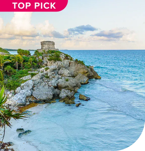 Ruins on a cliff overlooking a turquoise ocean with