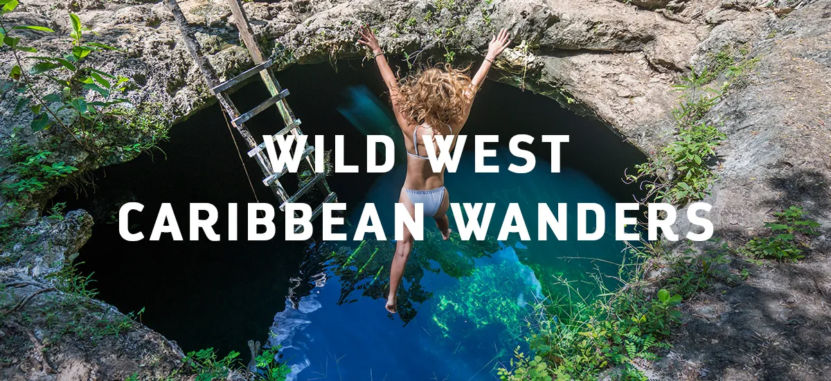 A woman jumps into a cenote. 