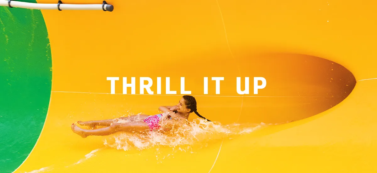 Woman on a water slide, splashing through water with 