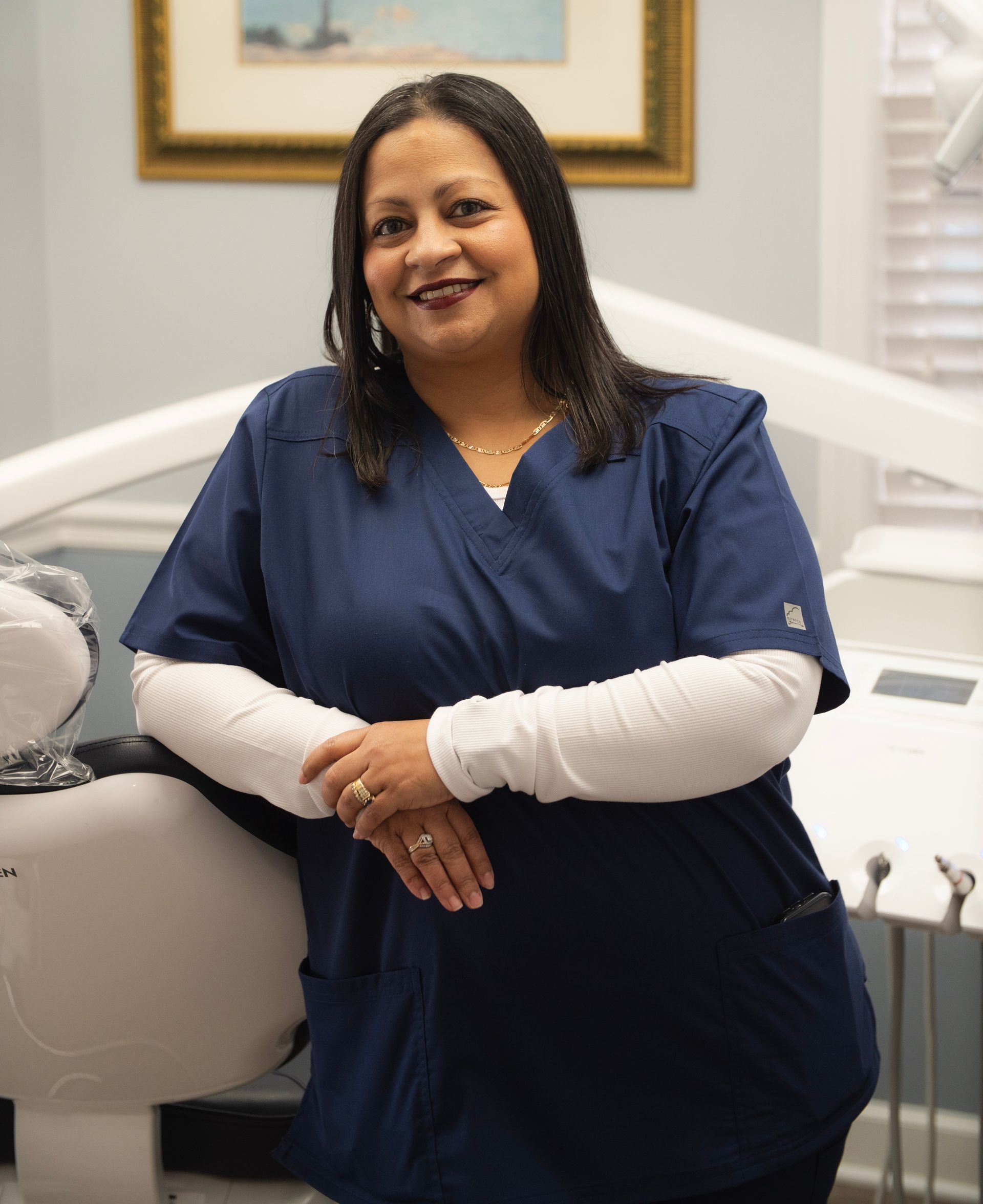 A woman with long black hair is smiling for the camera.