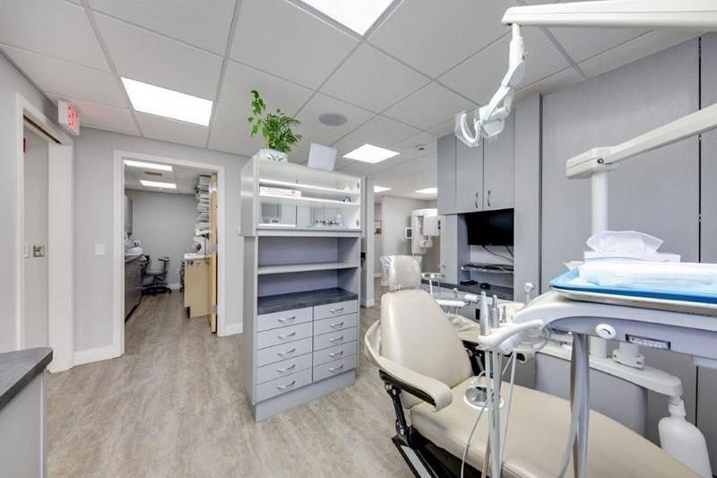 There is a dental chair in the middle of the room.