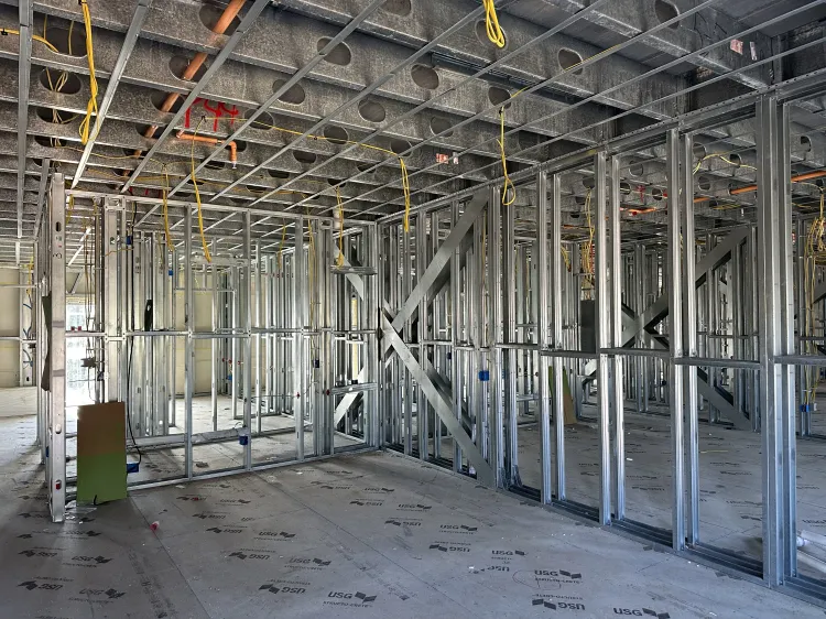 Interior of a building under construction with exposed metal framing and unfinished walls.