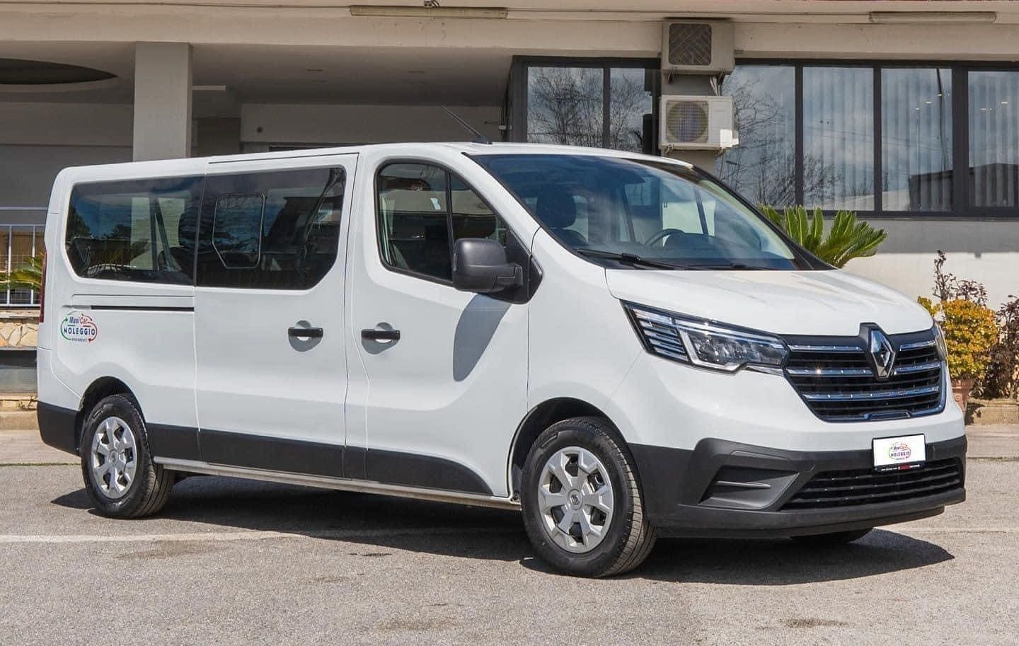 Un furgone bianco è parcheggiato davanti a un edificio.