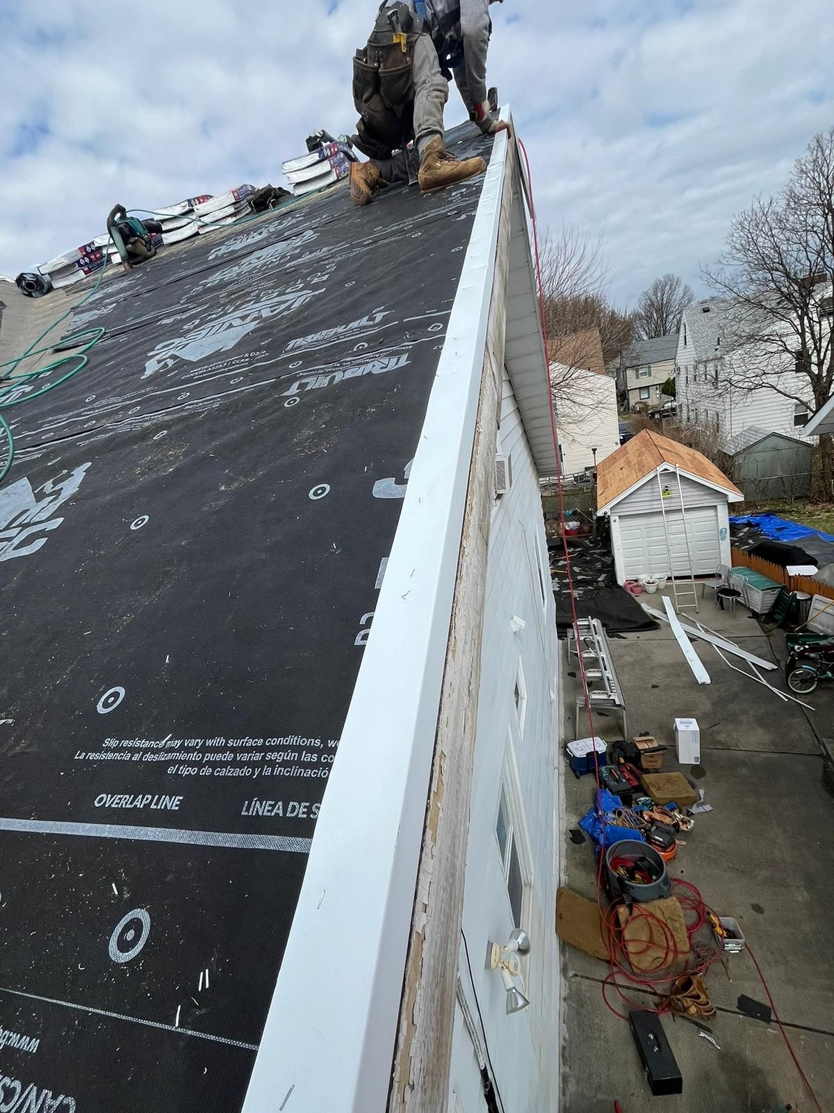 Construction workers on a rooftop installing roofing material.