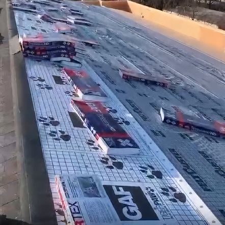 Roof in progress with GAF FeltBuster underlayment and shingle bundles.