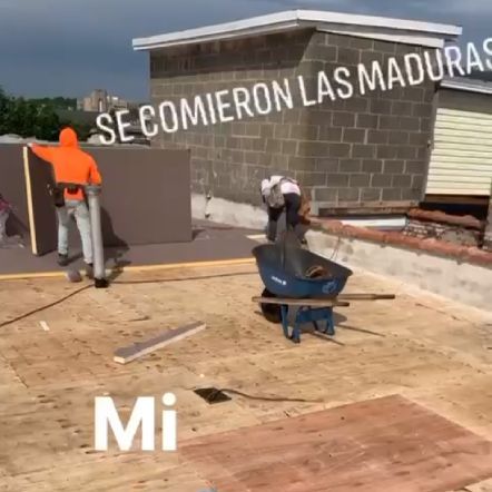 Construction workers on a rooftop, using a wheelbarrow, and large foam panels. The Spanish text overlay translates to 