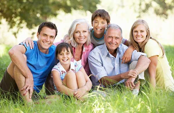 Una familia numerosa posa para una fotografía mientras está sentada en el césped.