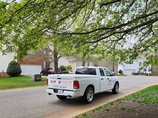 A White Truck Is Parked on The Side of The Road in A Residential Neighborhood — Newport News, VA — E & R Exterminating Company, Inc.