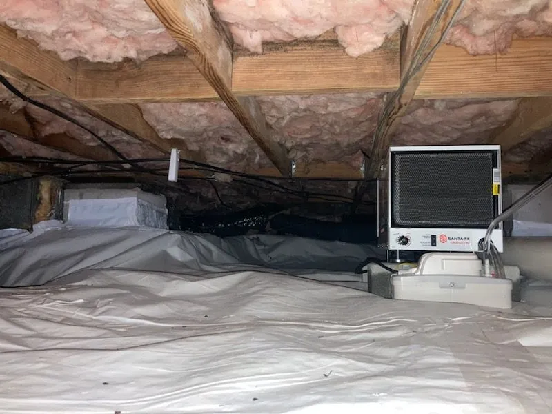 Encapsulated crawlspace with insulation overhead and a dehumidifier set on the vapor barrier. Encapsulated crawlspace with insulation overhead and a dehumidifier set on the vapor barrier.