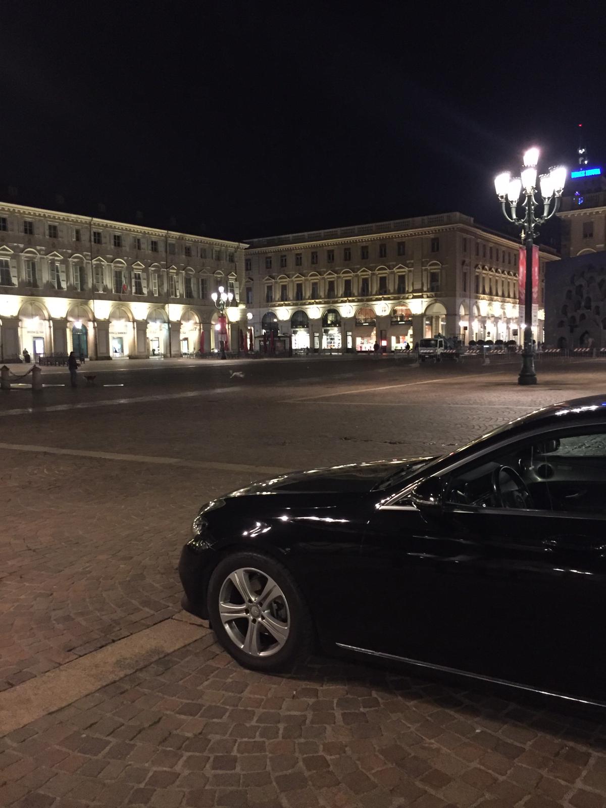 Un'auto nera è parcheggiata davanti a un edificio di notte