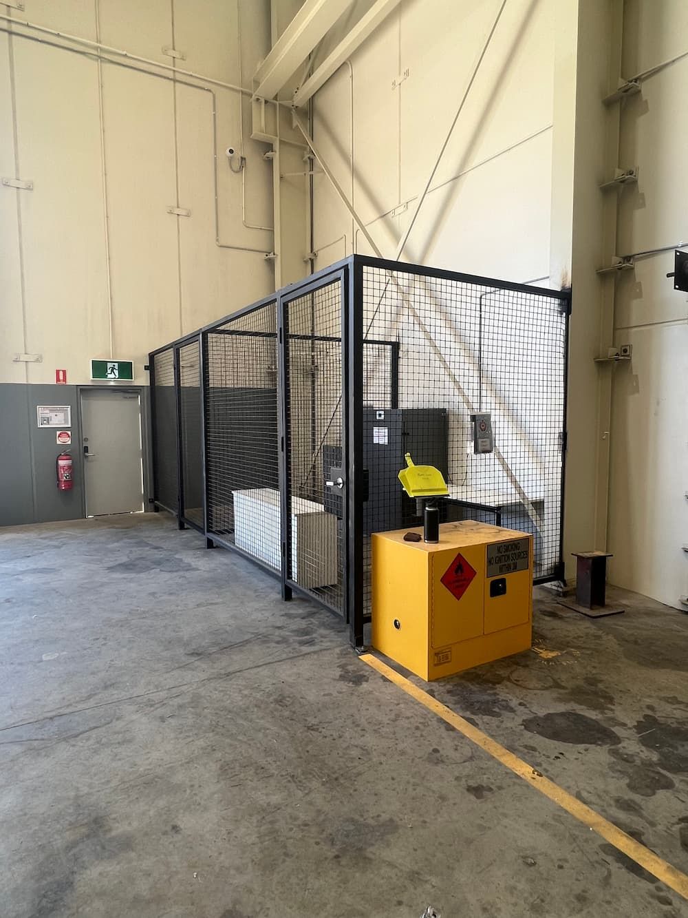 A Warehouse With A Fence And A Yellow Box That Says ' Flammable ' On It — Quality Fabrications & Welding Pty Ltd In Bohle, QLD