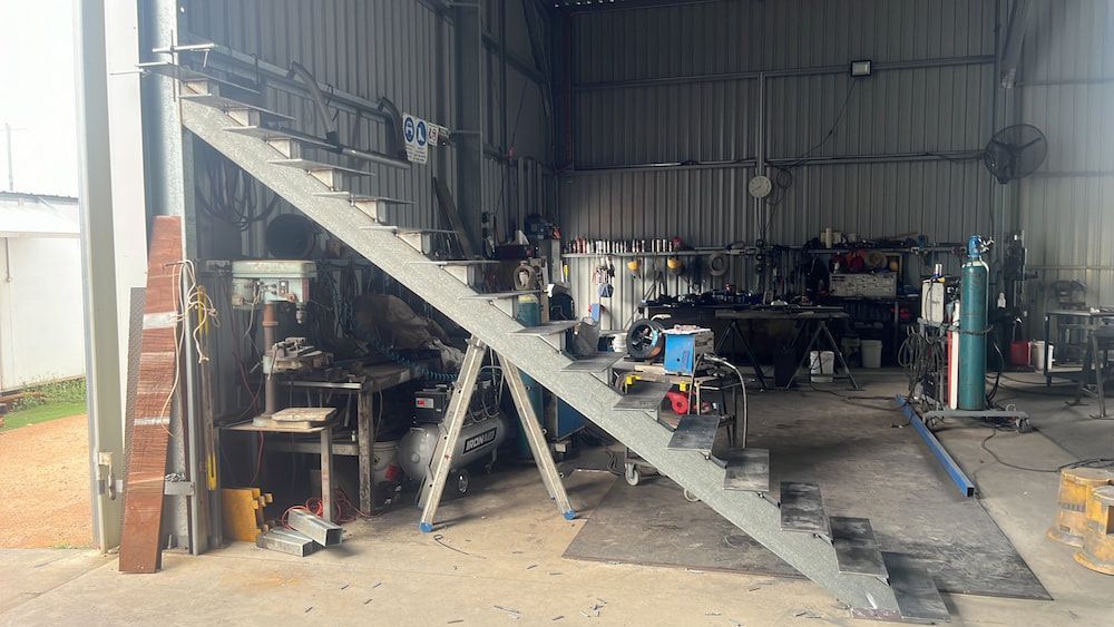 A Metal Staircase Is Being Built In A Factory — Quality Fabrications & Welding Pty Ltd In Bohle, QLD