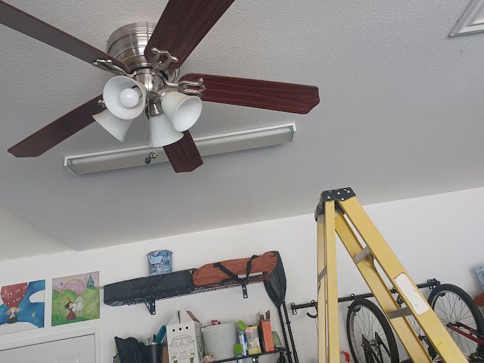 A ceiling fan is hanging from the ceiling of a garage