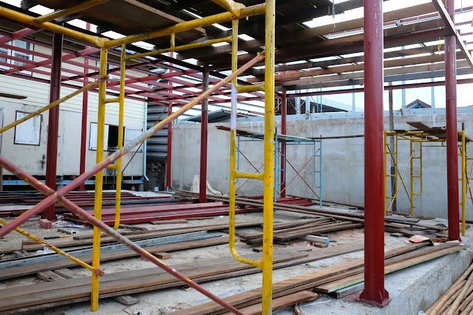 A building under construction with scaffolding and wooden beams.