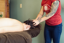Person receiving a head massage on a table in a spa-like room